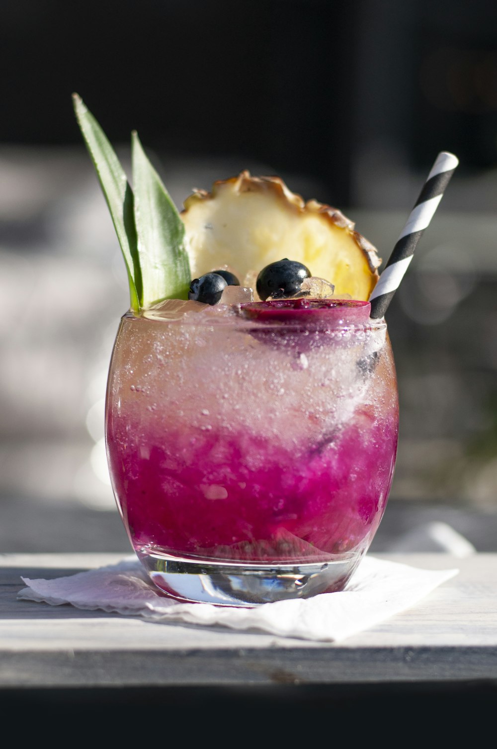 a drink with blueberries and pineapple on a table