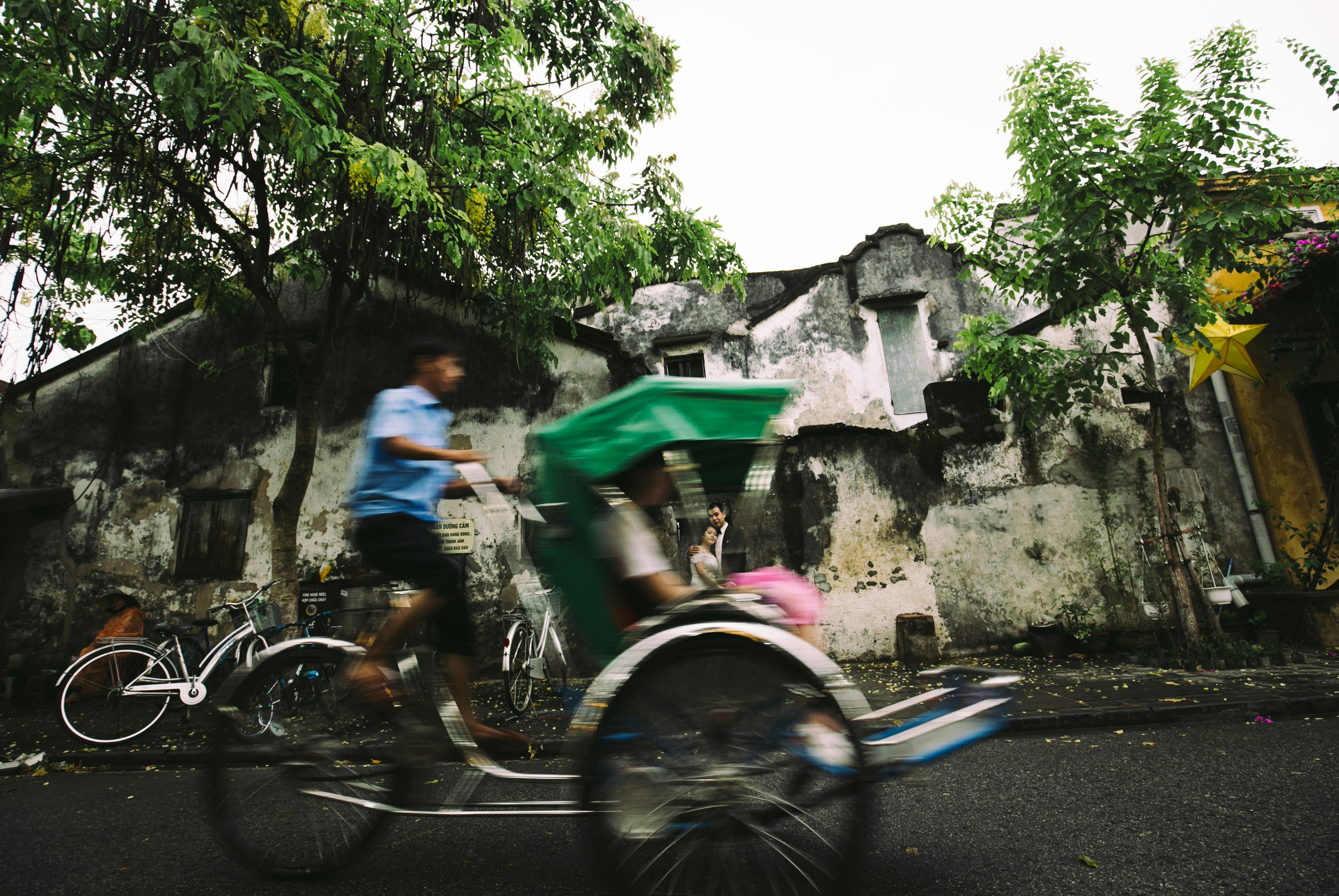a man riding a bike with a green basket on the back of it
