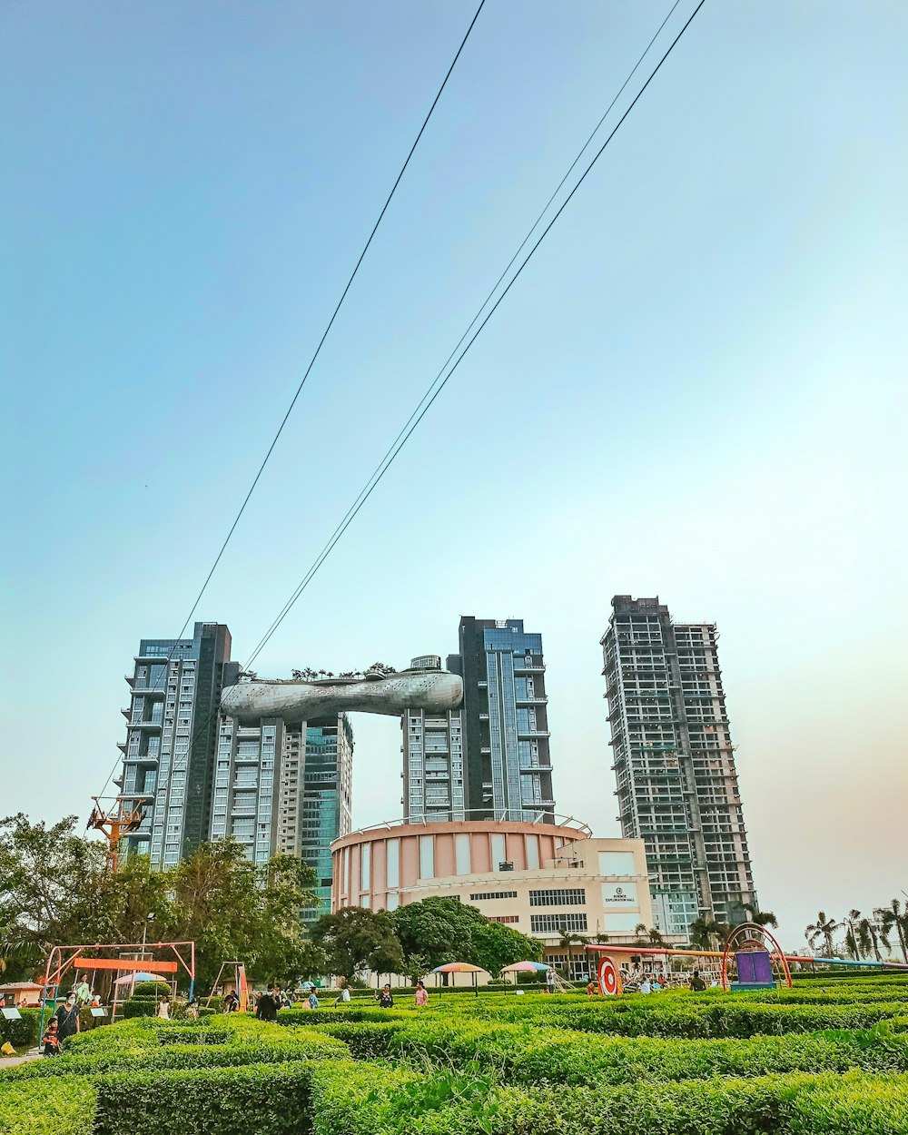 a couple of tall buildings sitting next to a lush green park