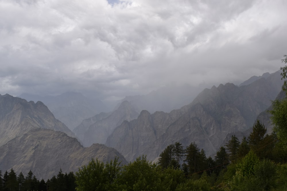 une vue d’une chaîne de montagnes avec un ciel nuageux