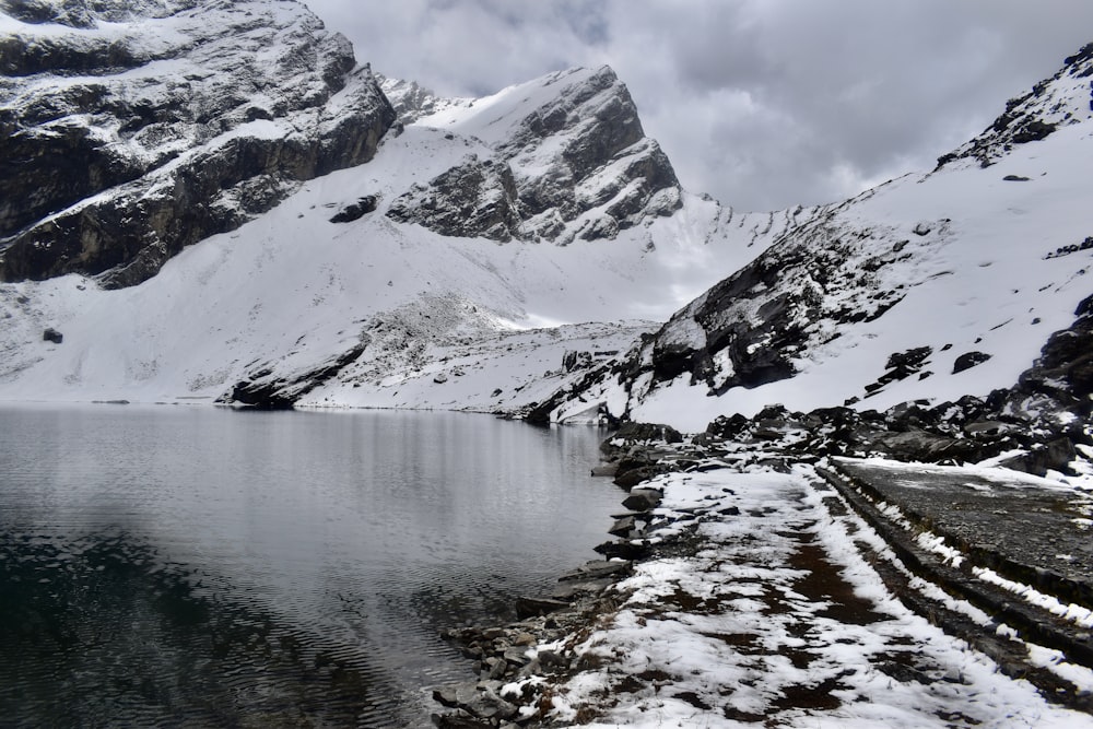 a snow covered mountain with a lake in the foreground