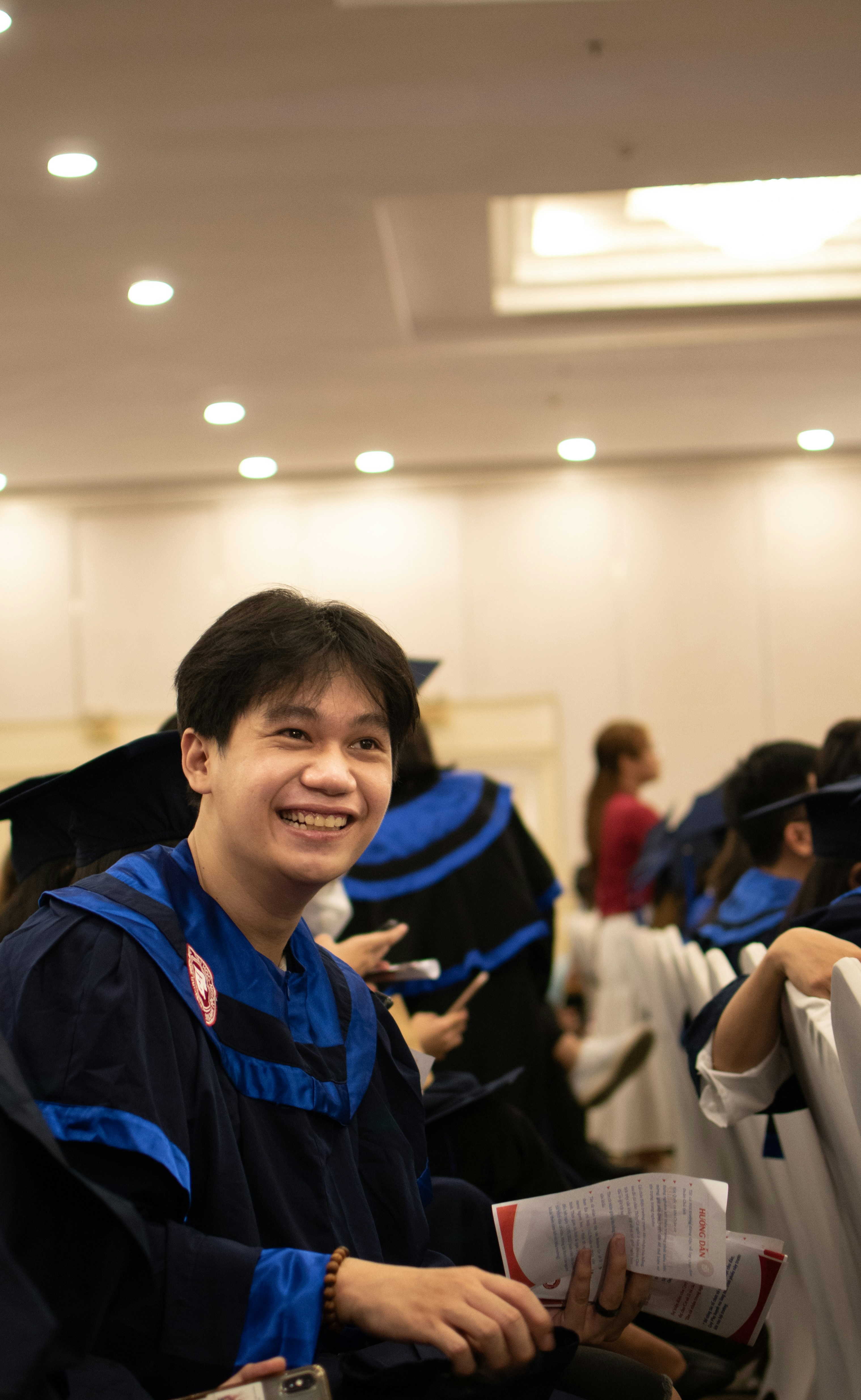 a man in a graduation cap and gown smiles at the camera
