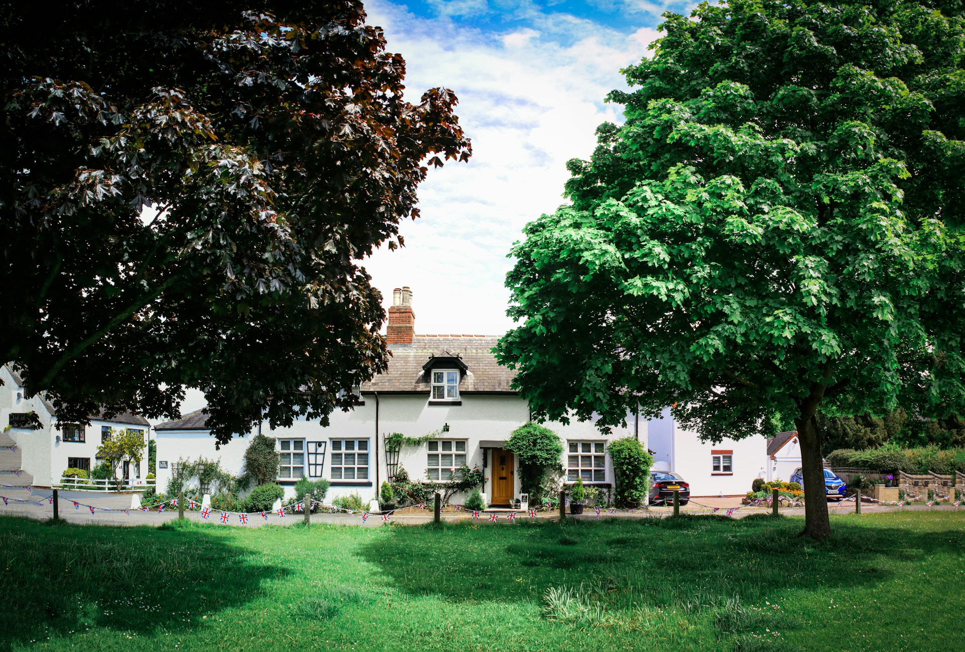 a large white house sitting next to a lush green field