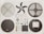 Various disassembled components of a fan displayed neatly on a flat surface. The parts include fan blades, protective grilles, electrical coils, small screws, electronic circuit board, and other mechanical pieces, all arranged in symmetrical fashion.