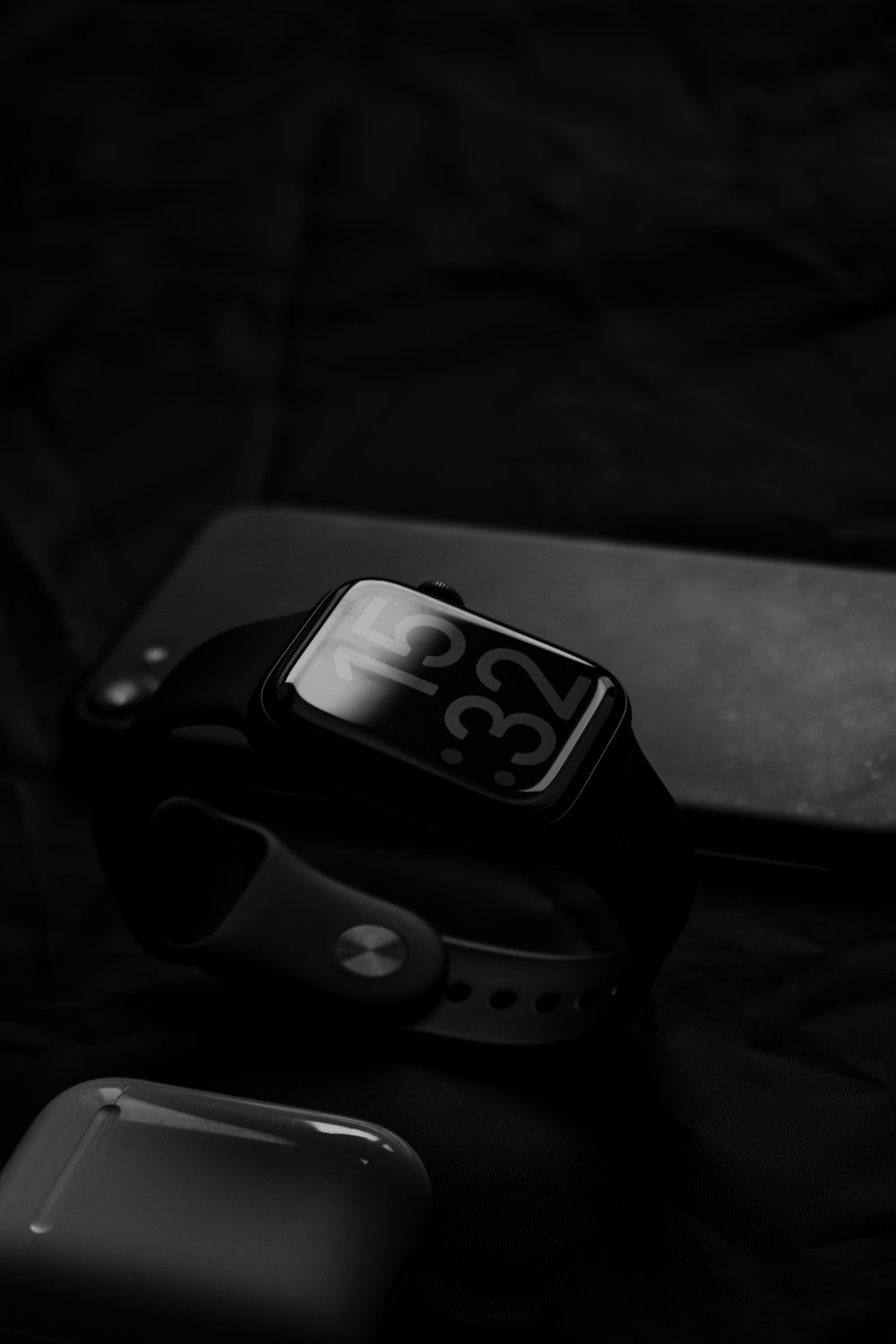 a smart watch sitting on top of a table next to a cell phone