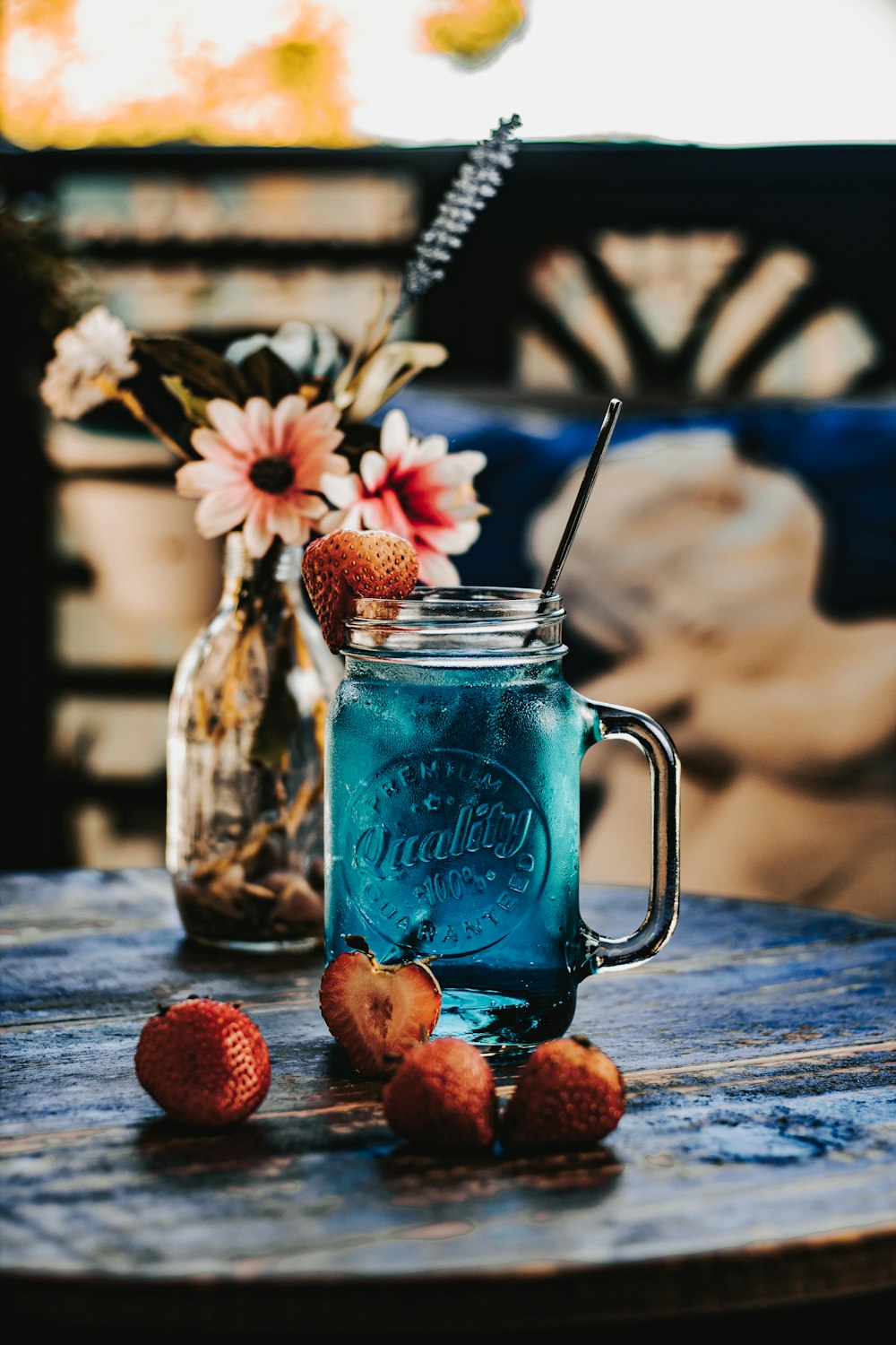 a blue mason jar with strawberries on a table