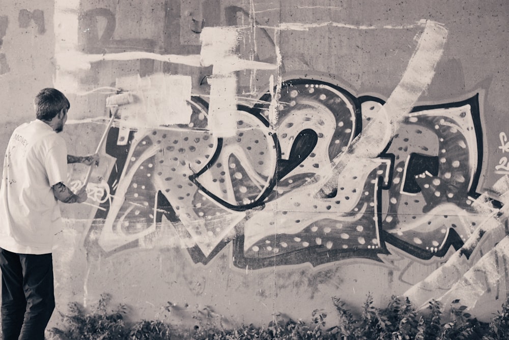 a man standing in front of a graffiti covered wall