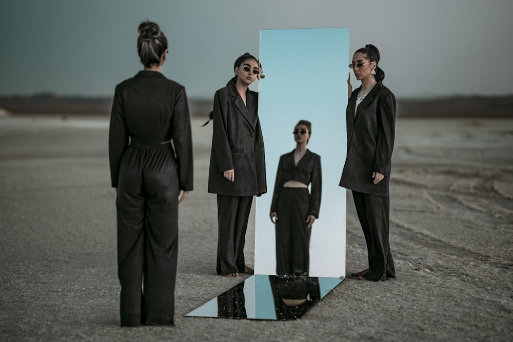 a group of women standing in front of a mirror