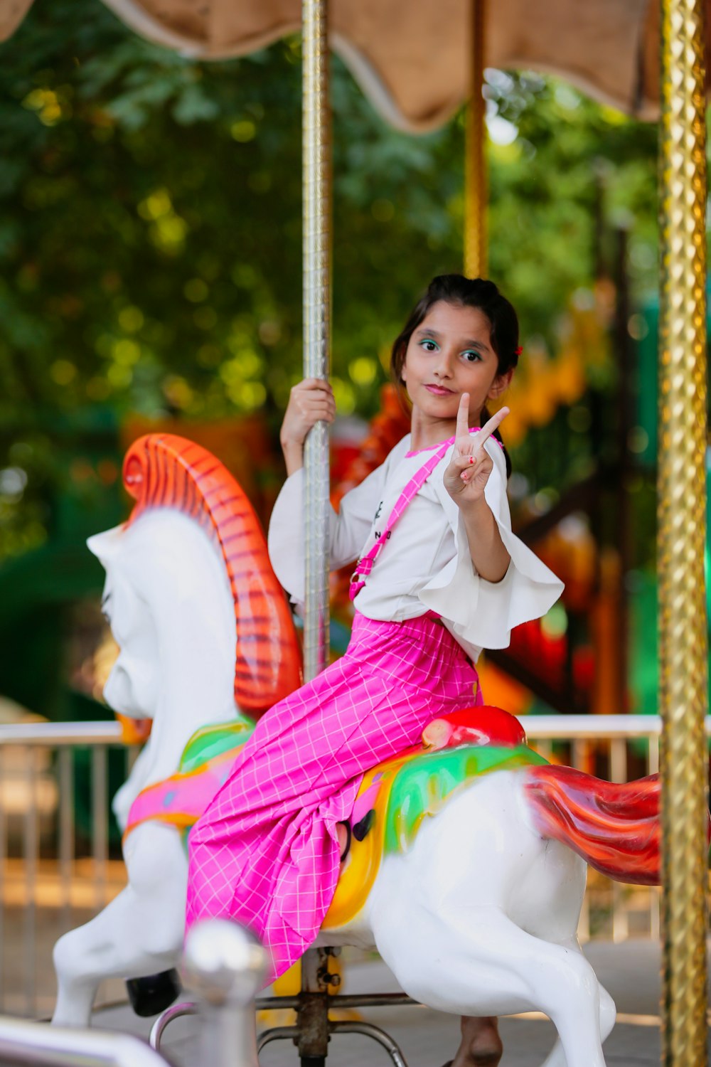 a little girl riding a merry go round on a merry go round