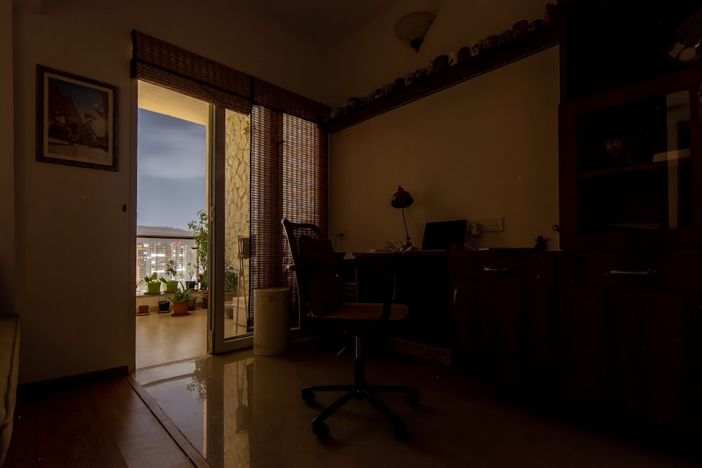 a dimly lit room with a desk and chair