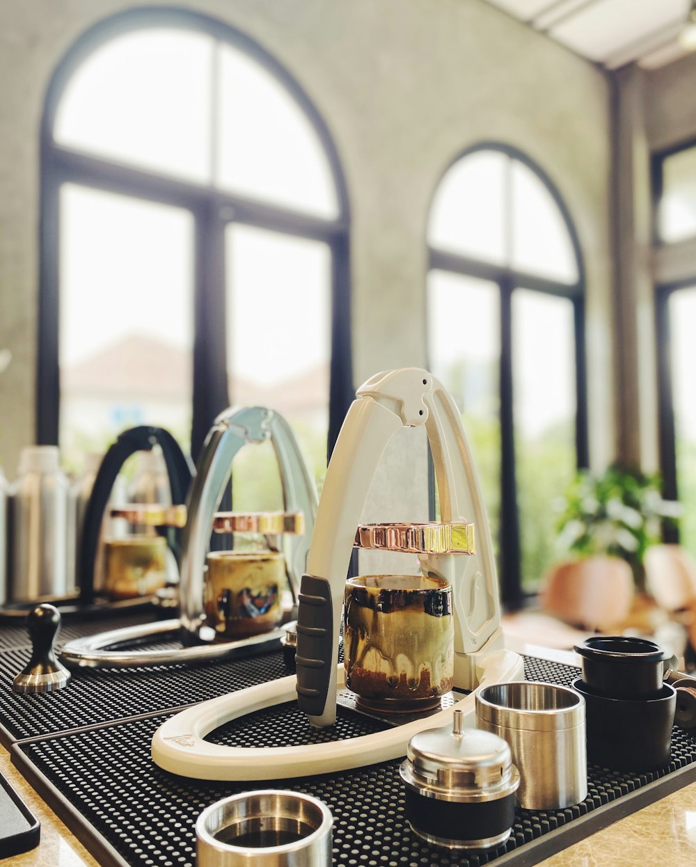 a kitchen counter with a blender and cups on it