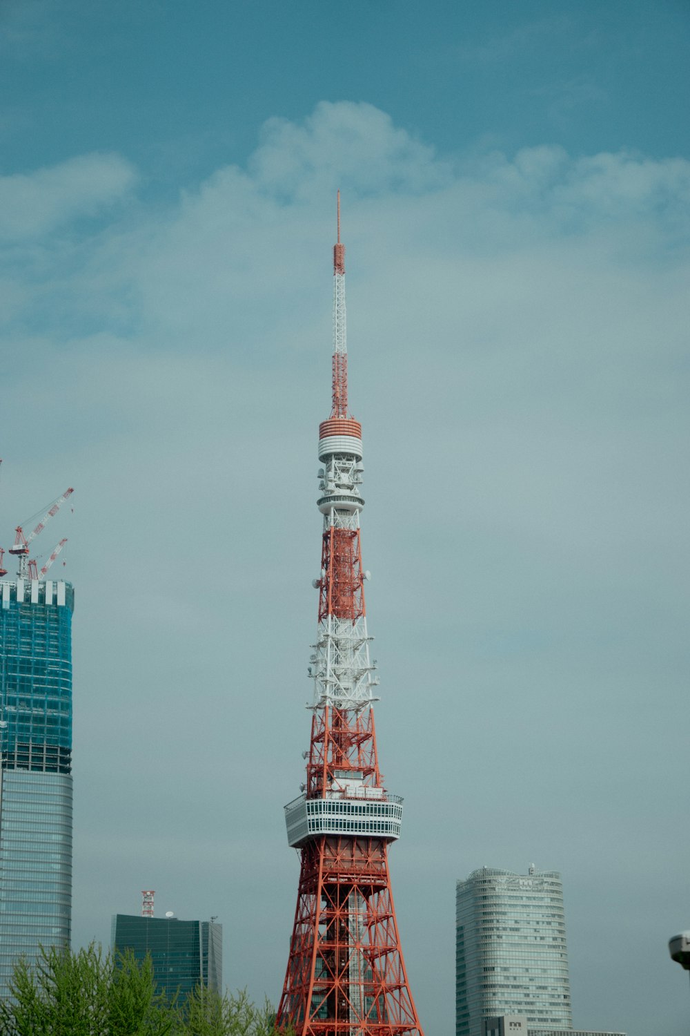 a very tall red and white tower in the middle of a city