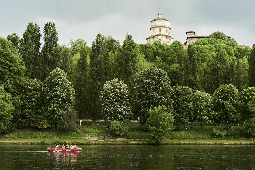 a red boat with people in it on a body of water