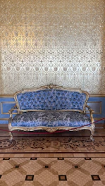 a blue couch sitting on top of a tiled floor