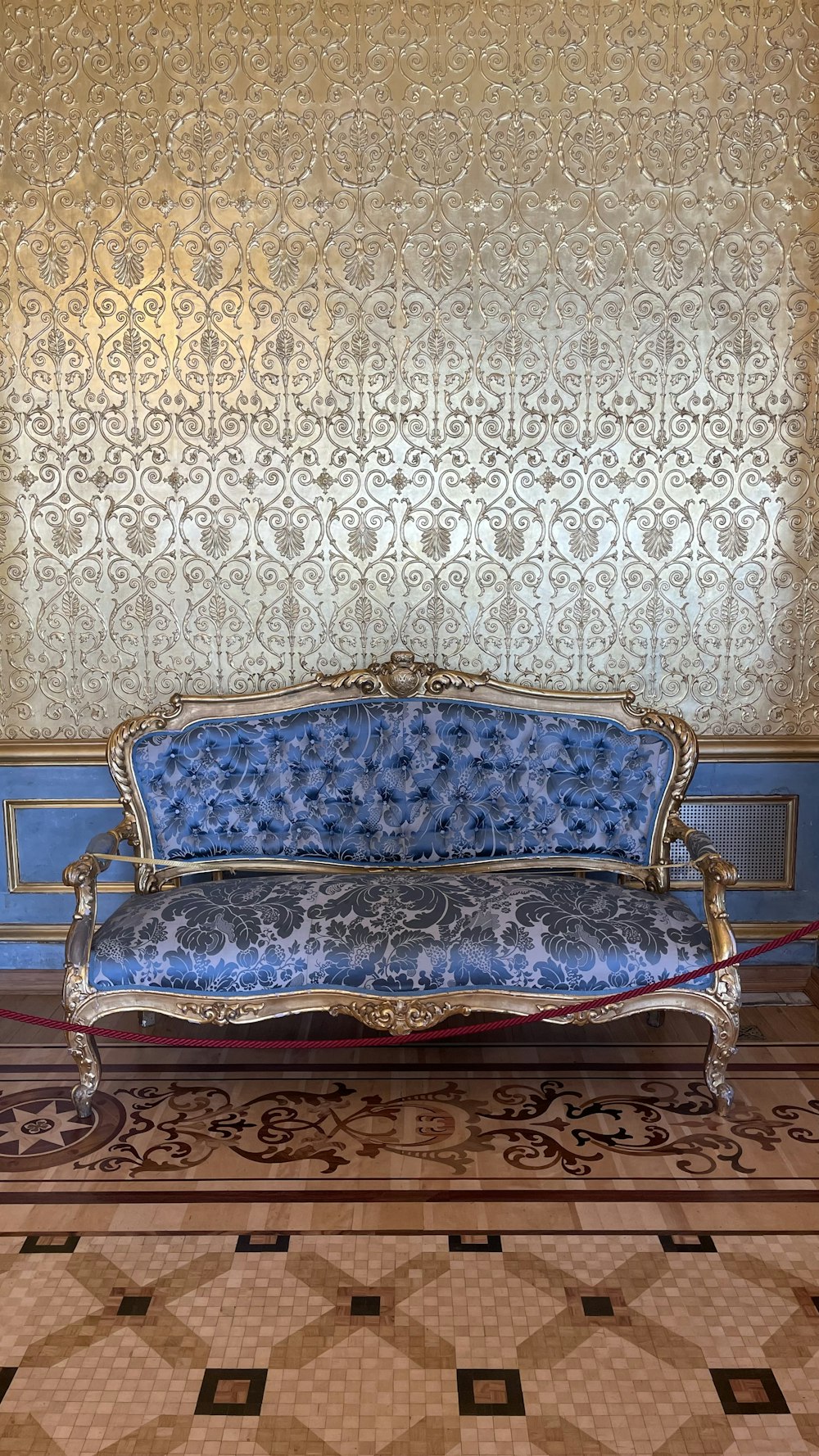 a blue couch sitting on top of a tiled floor