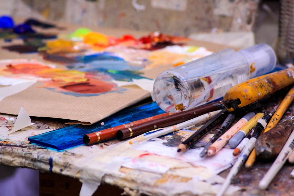 a bunch of paint brushes sitting on top of a table