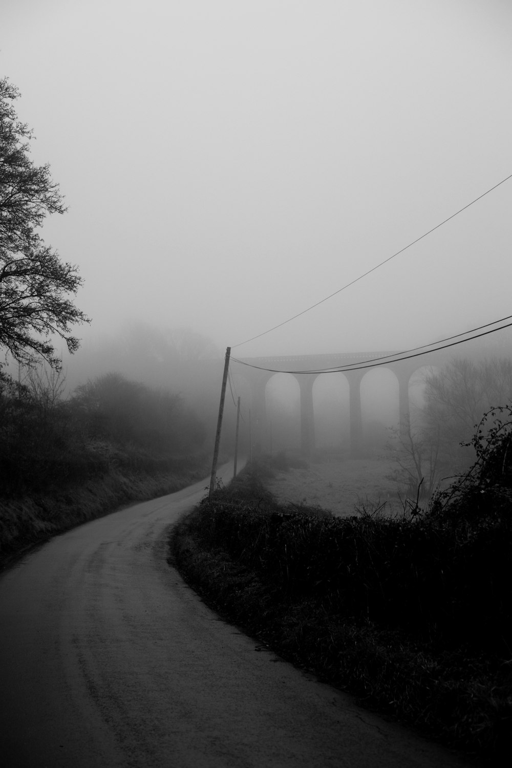 a black and white photo of a foggy road