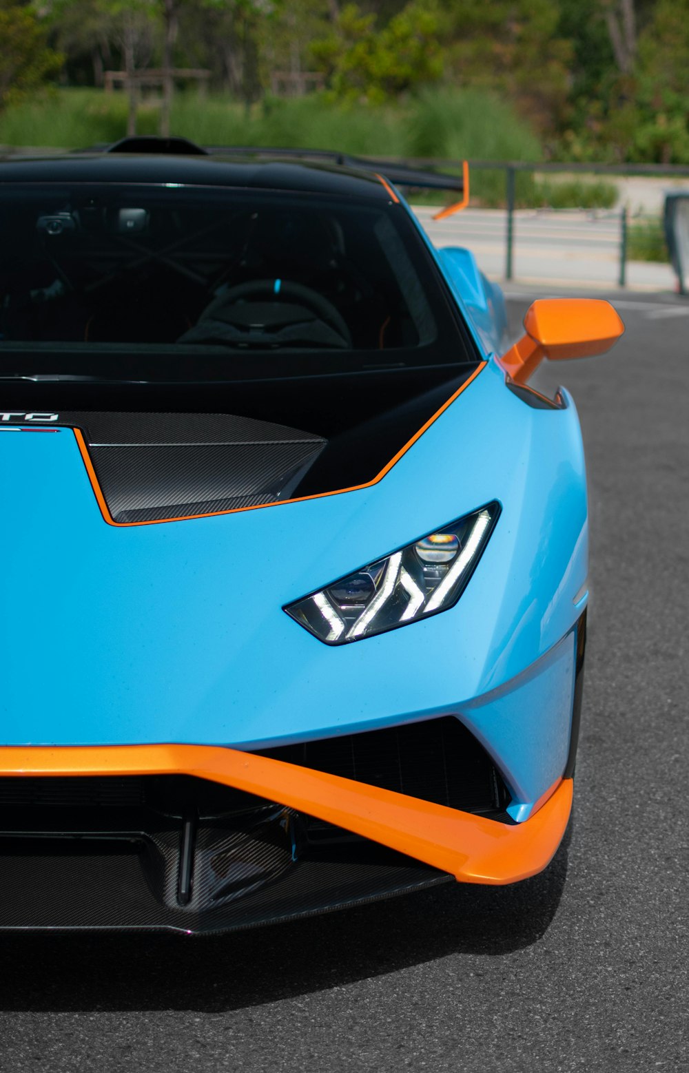 a blue and orange sports car parked in a parking lot