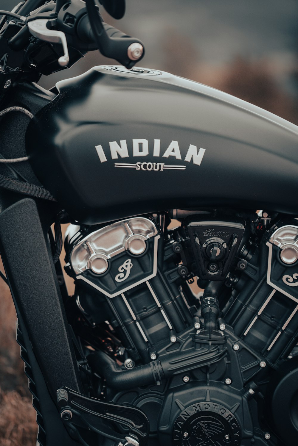 Una motocicleta Scout india negra estacionada en un campo
