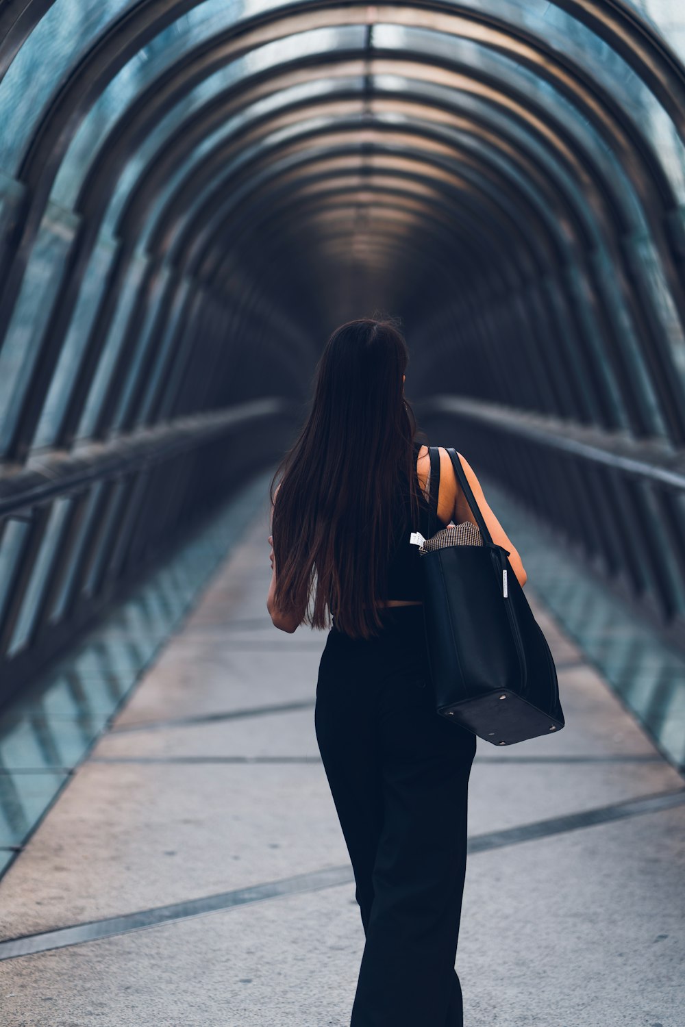 Aplicable Tomar represalias estético Foto Una mujer caminando por una pasarela con una bolsa negra – Imagen  Caminar por la ciudad gratis en Unsplash