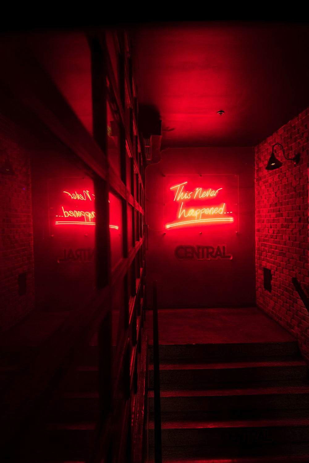 a dark hallway with red neon signs on the walls