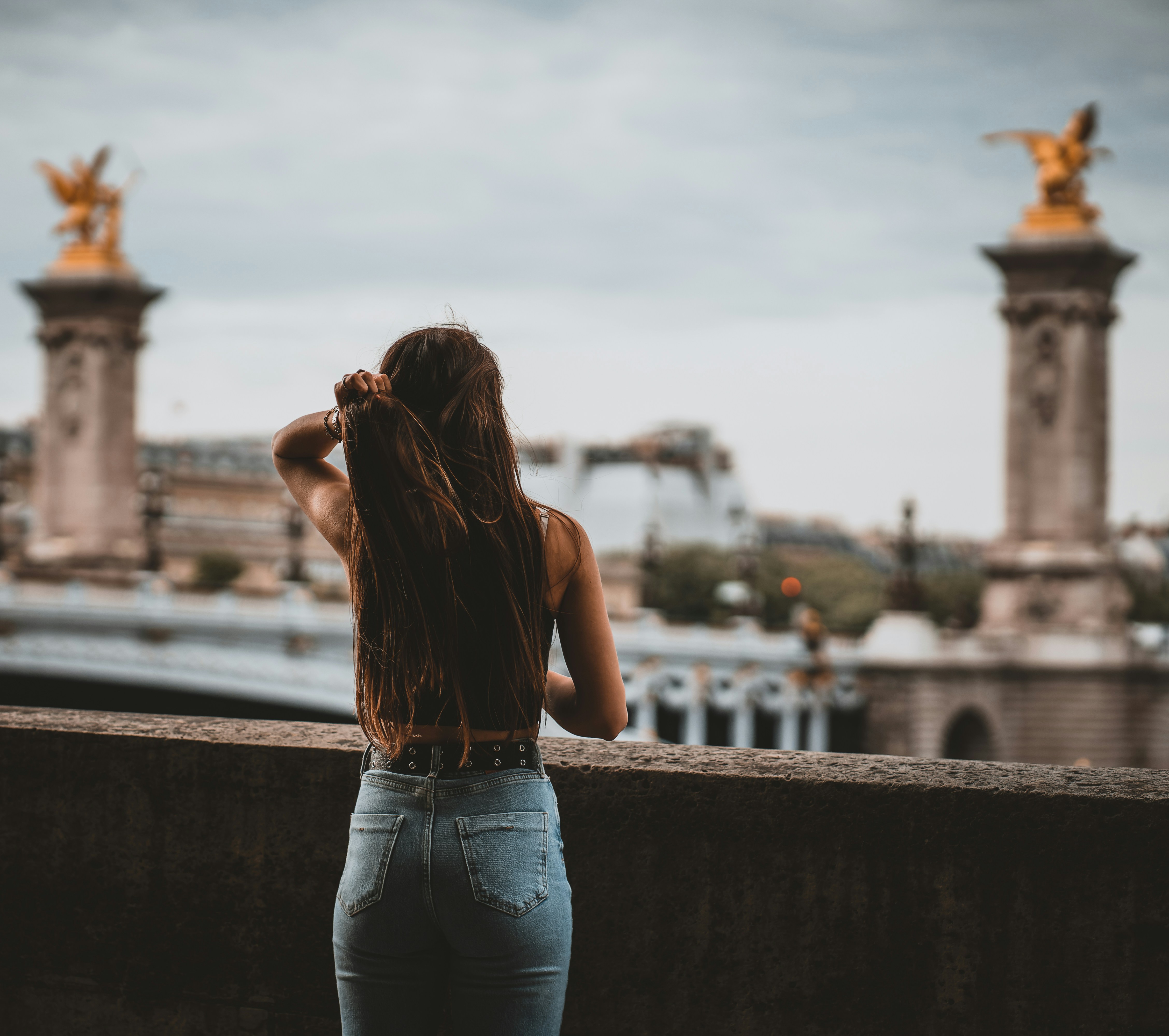 a woman standing on top of a bridge next to a tall building