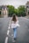 a woman walking down the middle of a street