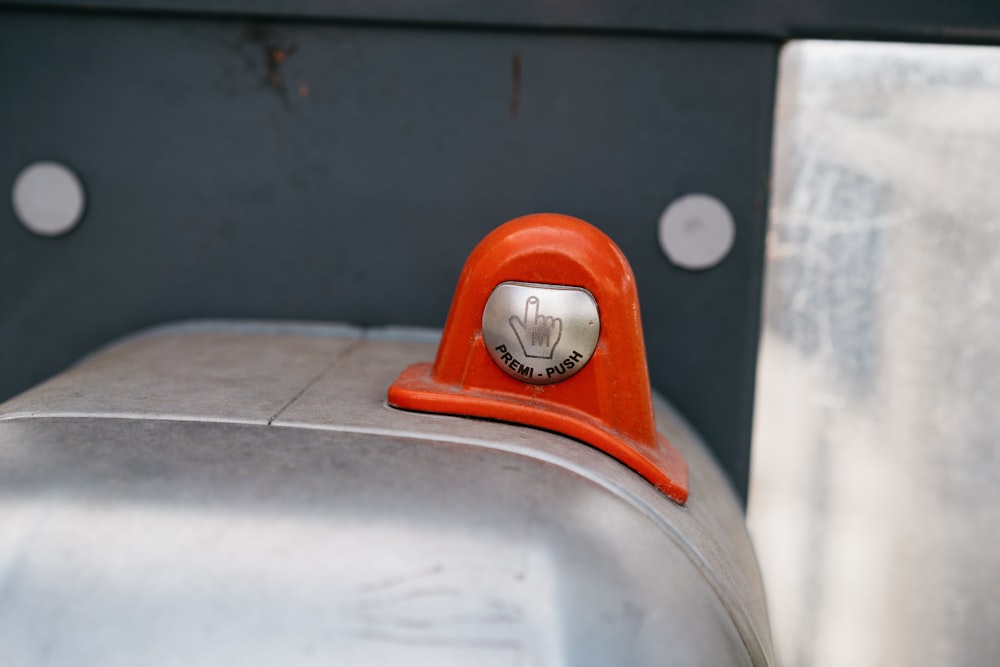 a close up of a metal object with a red handle