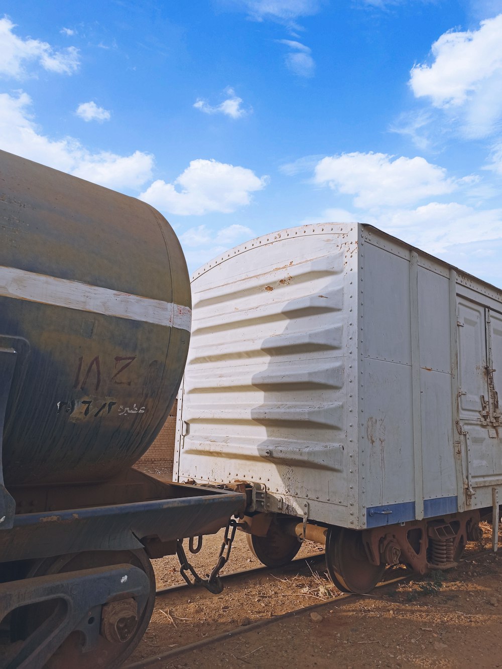 a train car sitting on the tracks with a sky background