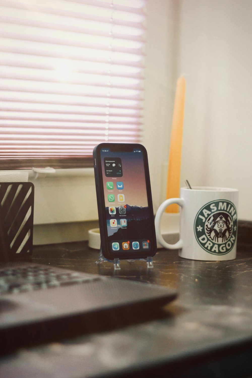 a cell phone sitting on top of a table next to a cup of coffee