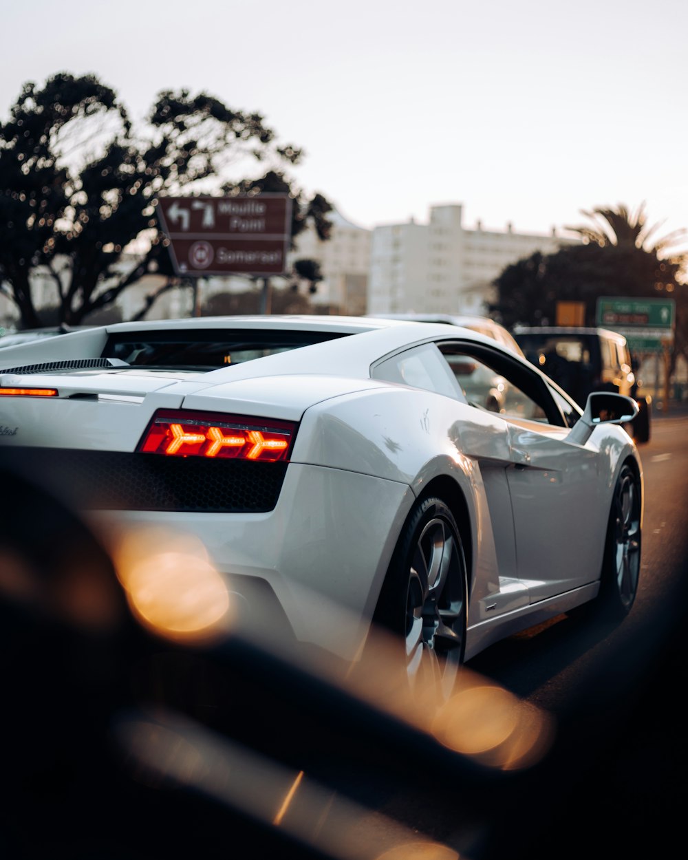 a white sports car driving down a street