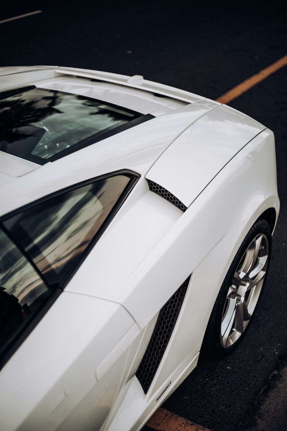 a white sports car parked on the side of the road