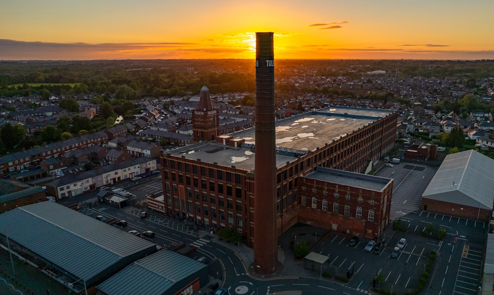 an aerial view of a factory with a sunset in the background
