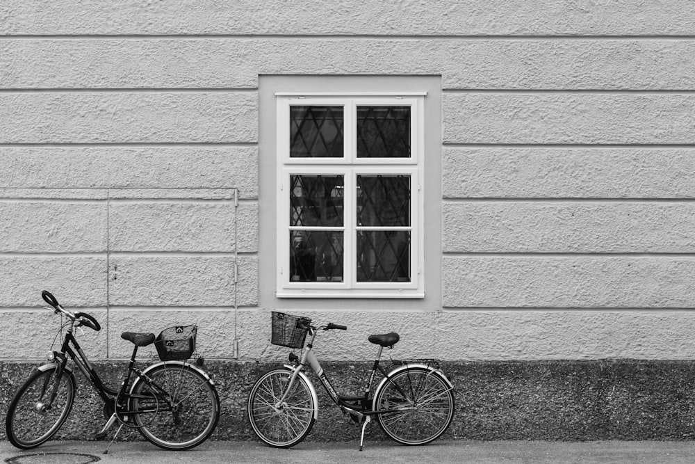 two bikes parked next to each other in front of a window