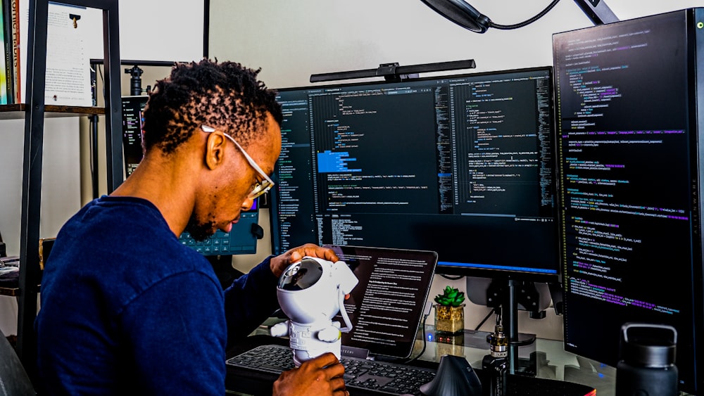 a man is looking through a microscope at a computer