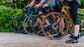 a group of people riding bikes down a dirt road