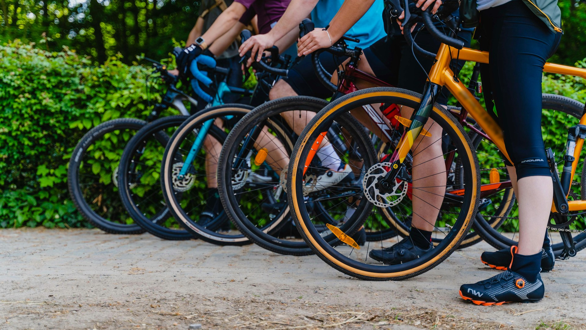 a group of people riding bikes down a dirt road