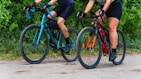 a couple of people riding bikes down a road
