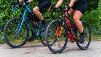 a couple of people riding bikes down a road