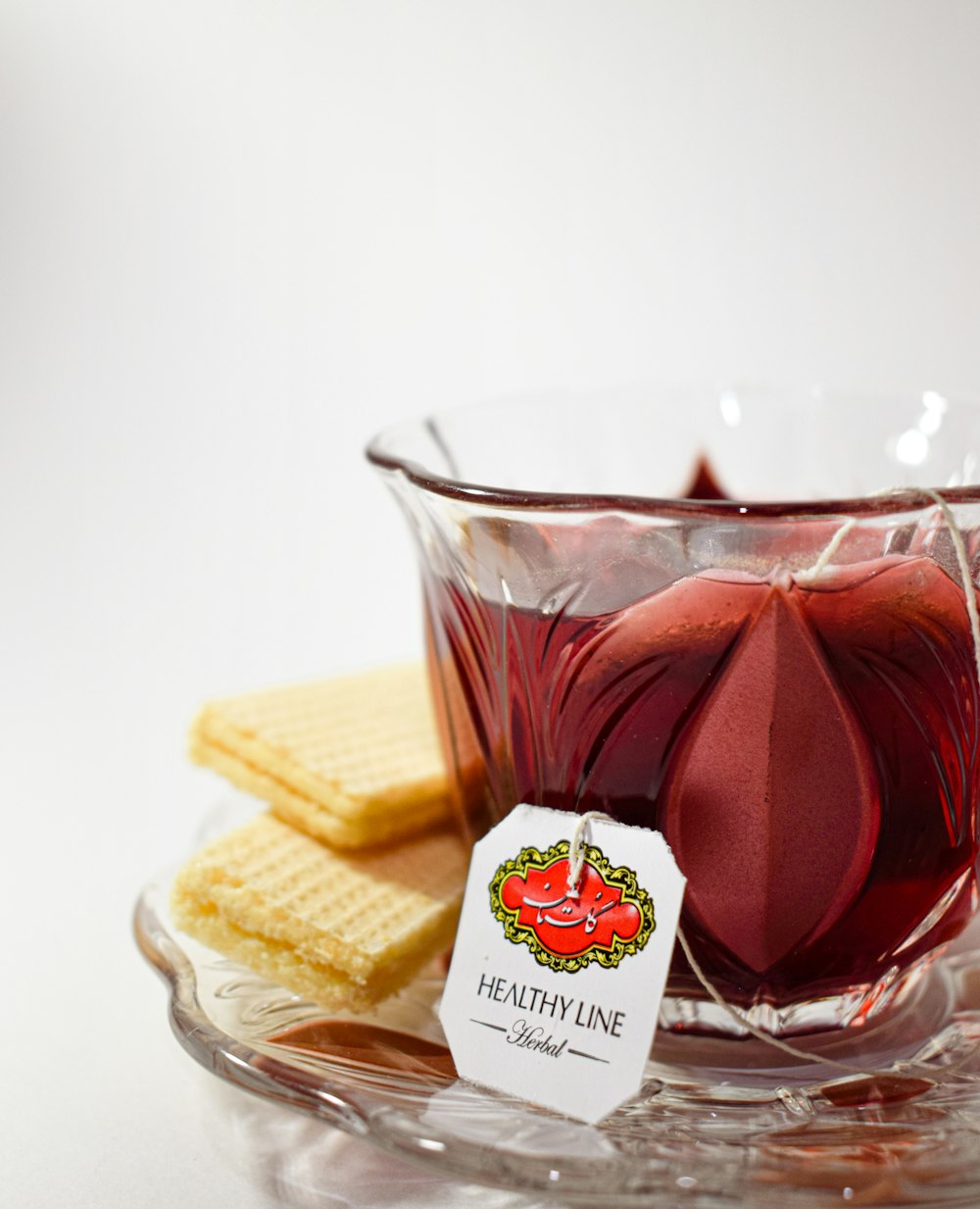 a glass cup filled with liquid next to crackers