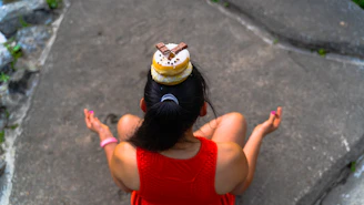a woman in a red dress sitting on a rock
