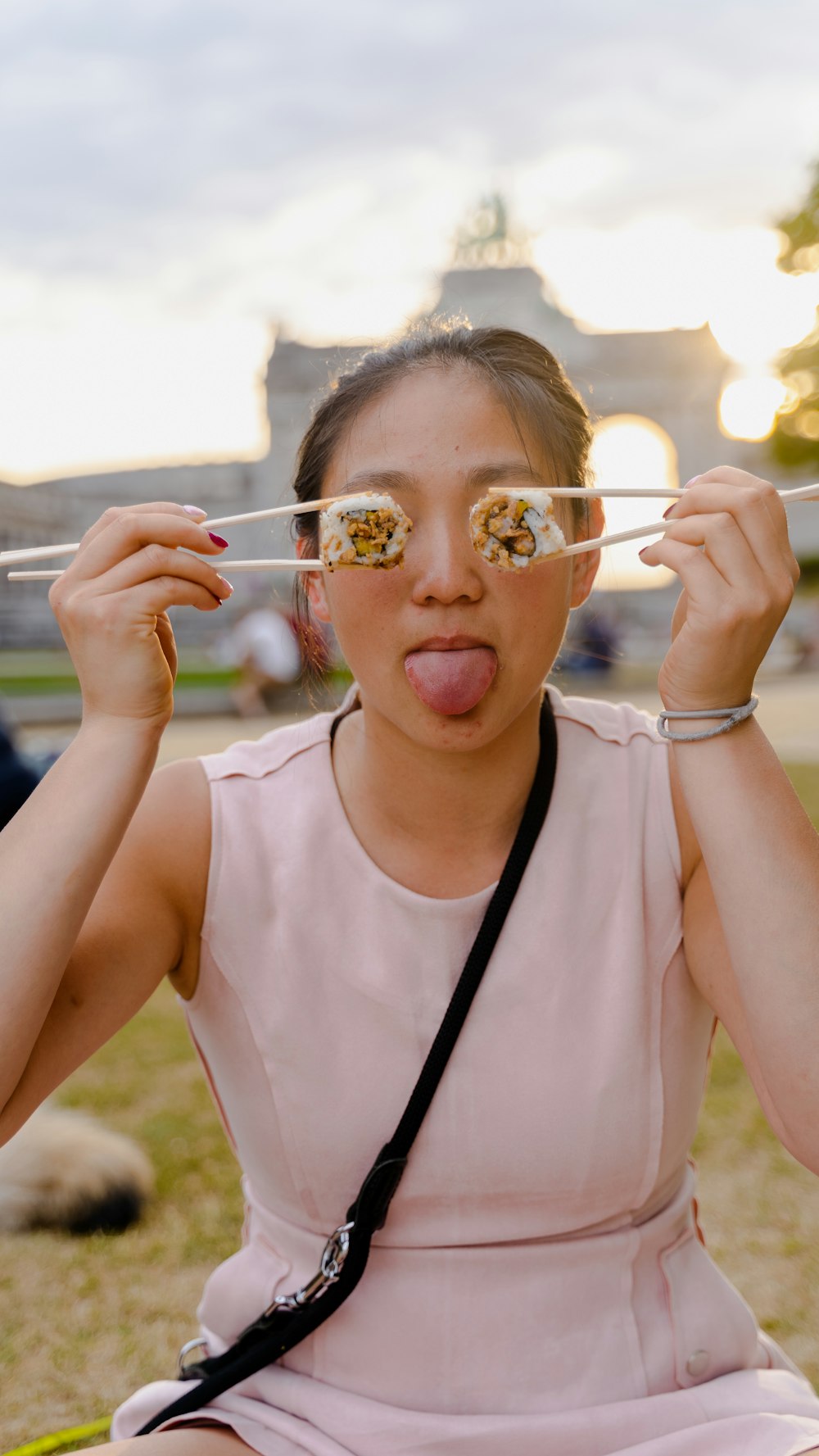 a woman sitting on a bench holding a pair of glasses over her eyes