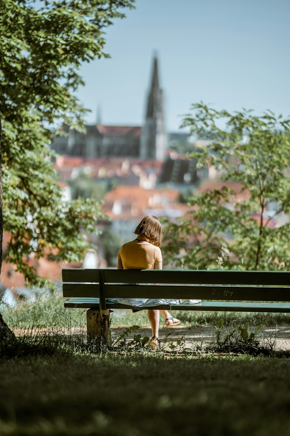 a woman sitting on a bench in a park