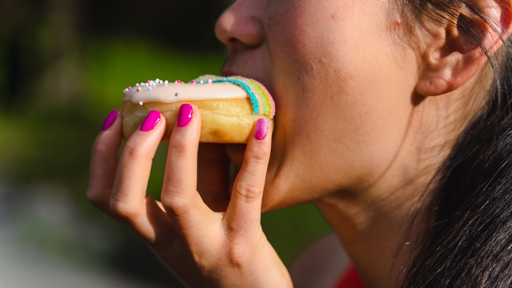 a woman eating a donut with sprinkles on it