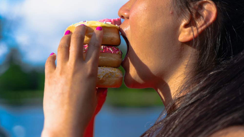 a woman eating a donut with sprinkles on it