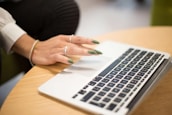 a woman sitting at a table using a laptop computer