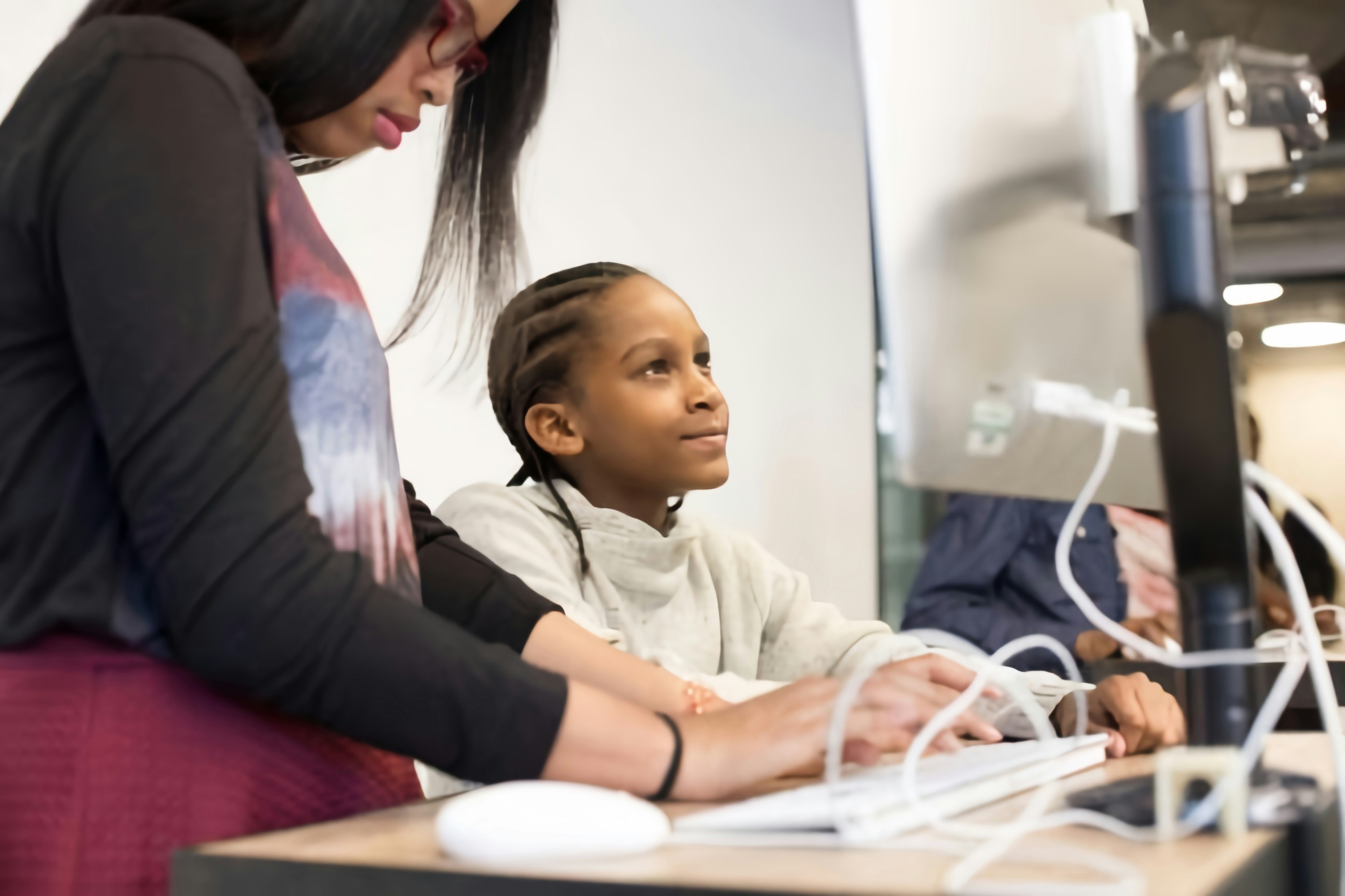 Teacher warmly guiding a student at a bright learning desk