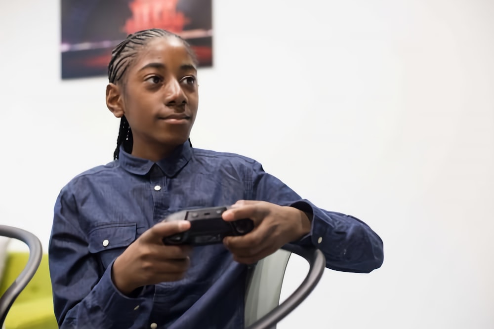 a woman sitting in a chair holding a remote control