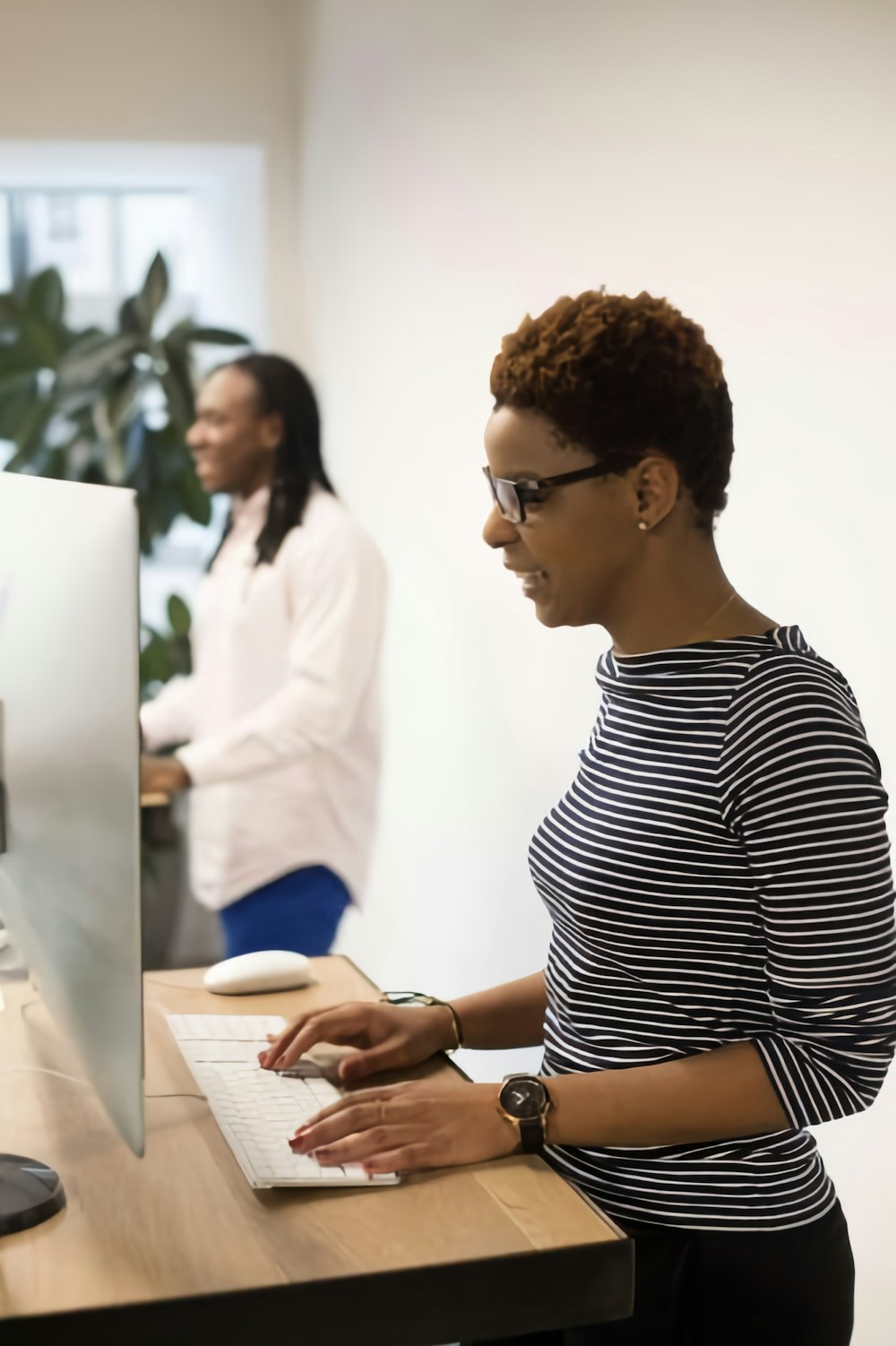 a woman sitting at a desk using a computer