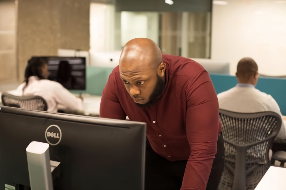 a man looking at a computer screen in an office